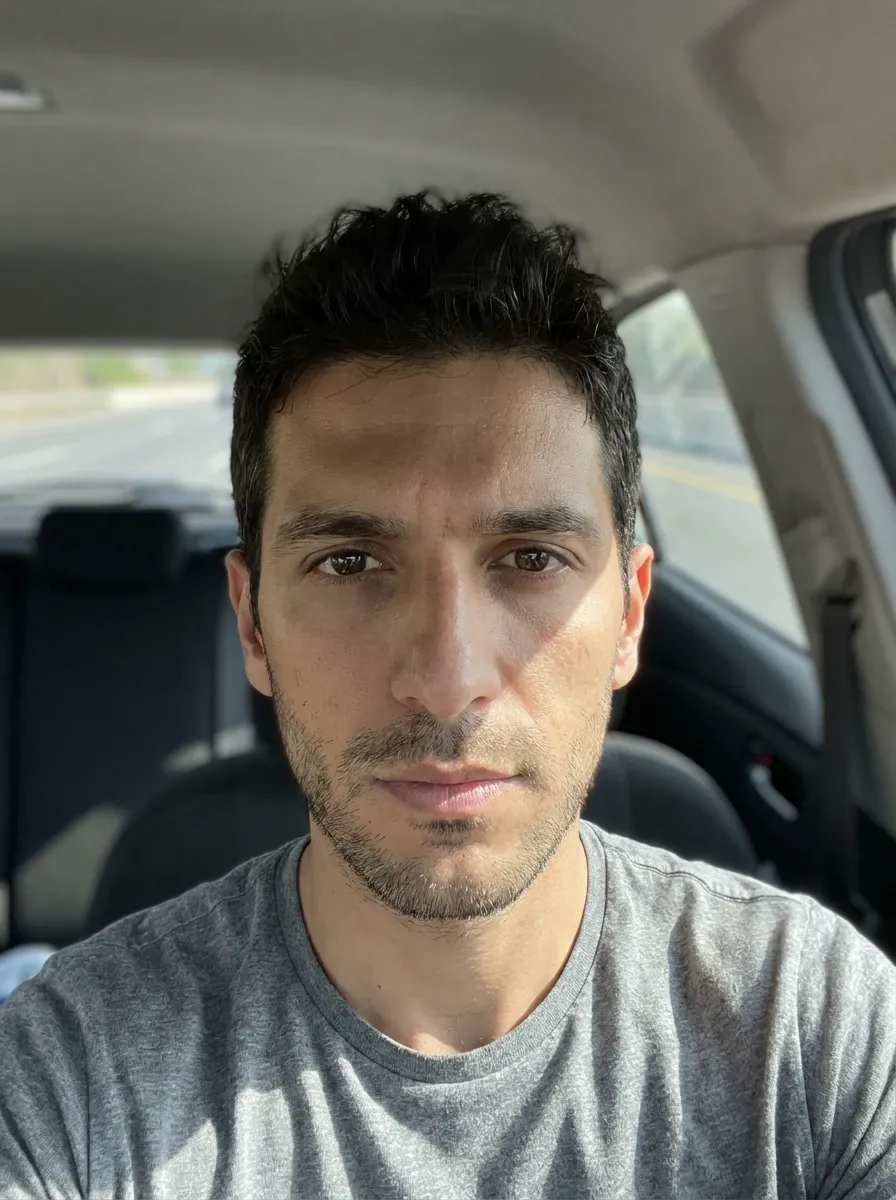 Original selfie input — man in a gray T-shirt taking a car selfie